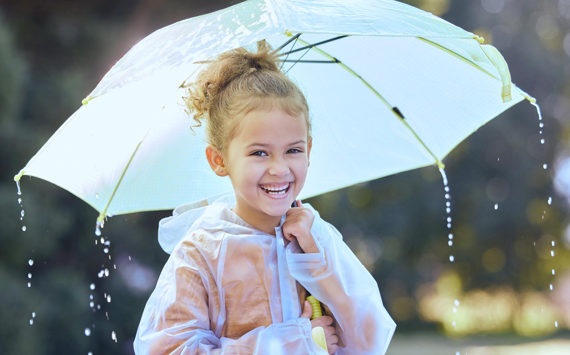 Piccola bambina che gioca con un ombrello grande nei giorni di